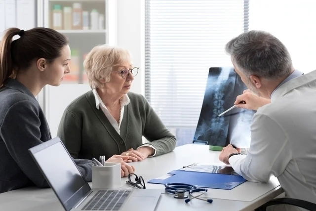 Médico mostrando una radiografía a una paciente y su acompañante