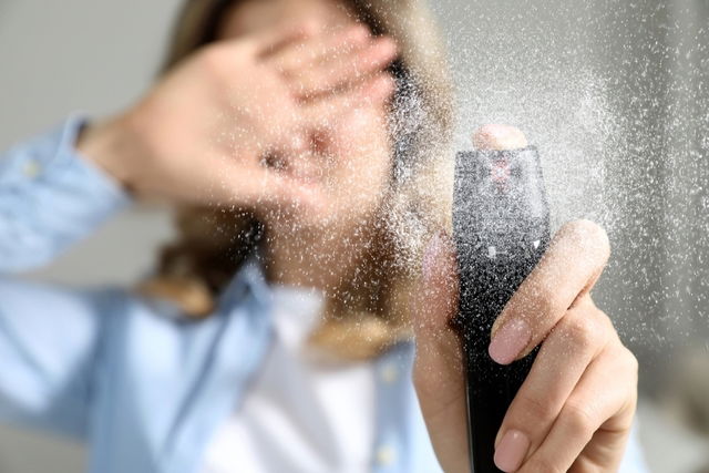 Woman holding aerosol spray