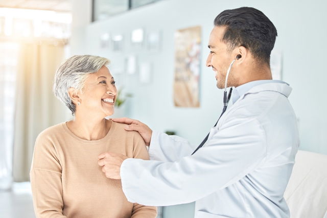 Médica ouvindo o coração de um paciente durante a consulta