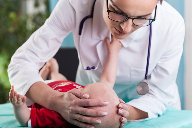 Pediatra evaluando al bebé durante la consulta médica