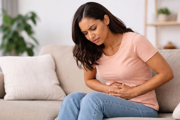 Woman in discomfort on sofa | AI-generated image