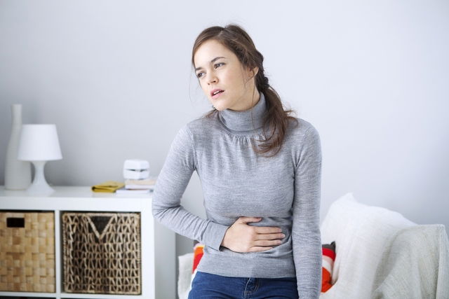 femme se touchant le ventre de douleur