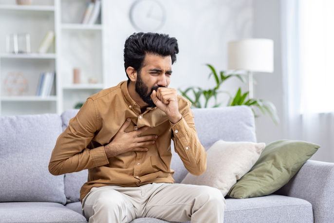 Man coughing intensely and holding chest