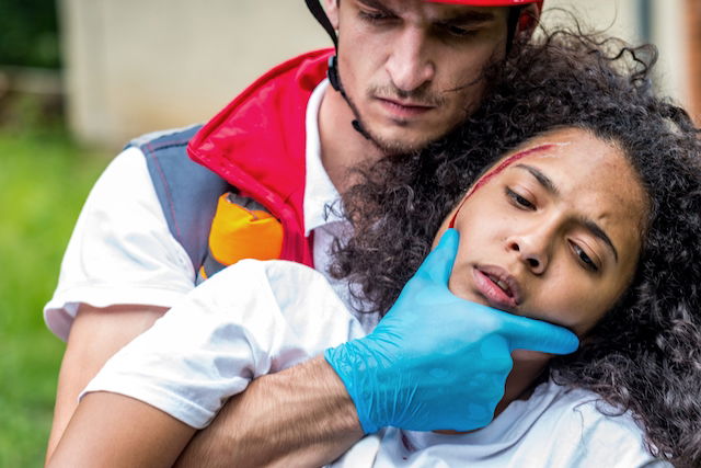 first responder holding woman with blood on her head