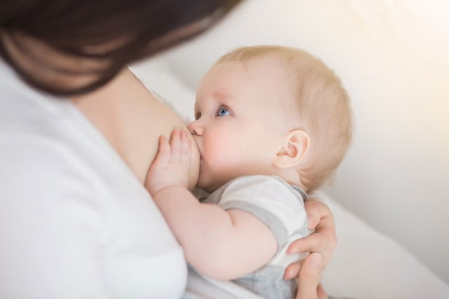 Mãe amamentando bebê no peito