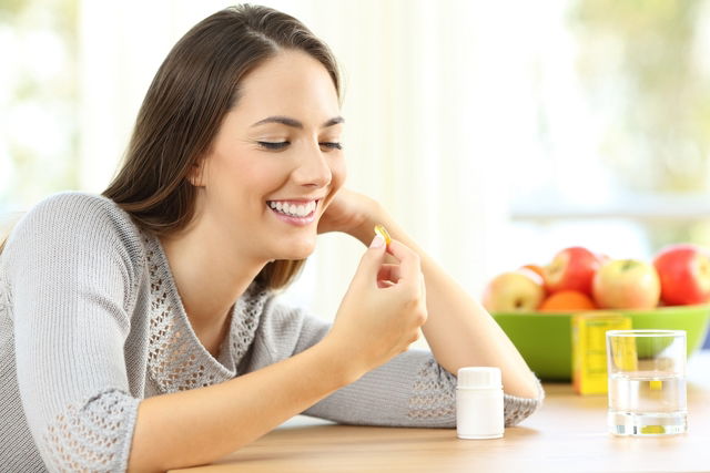 Mujer tomando una cápsula