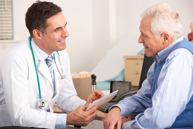 Médico conversando com um paciente de idade no consultório