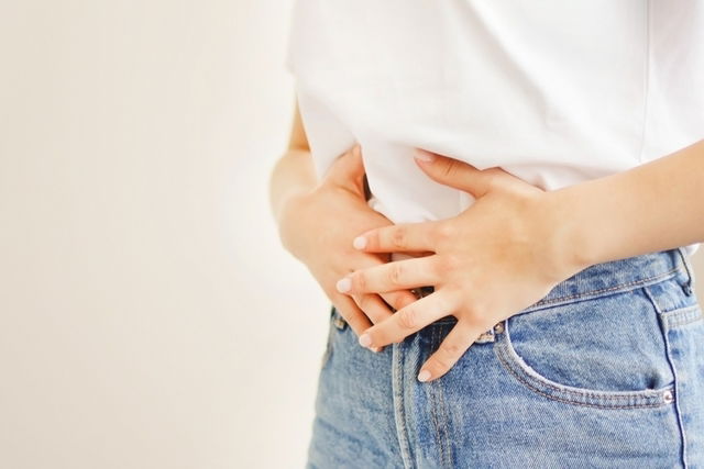 Mujer con dolor de abdomen. Sujetando el vientr