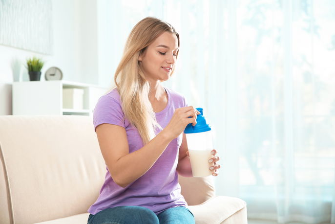 woman in purple shirt holding a shake