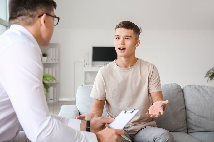 Adolescente explicando seus sintomas para o médico durante a consulta