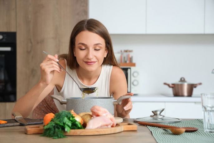 Woman smelling soup broth