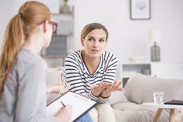 Mulher conversando com a psiquiatra durante a consulta.