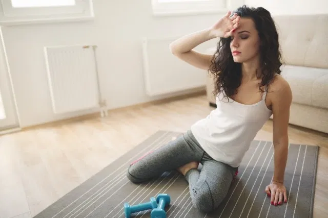 femme assise par terre qui se tient la tête