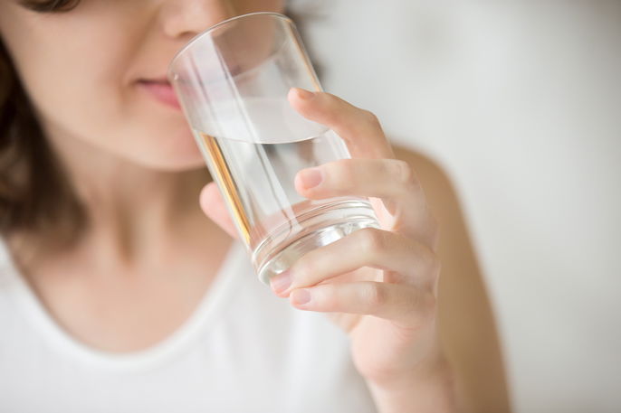 femme se plaignant de bouche sèche qui boit de l'eau