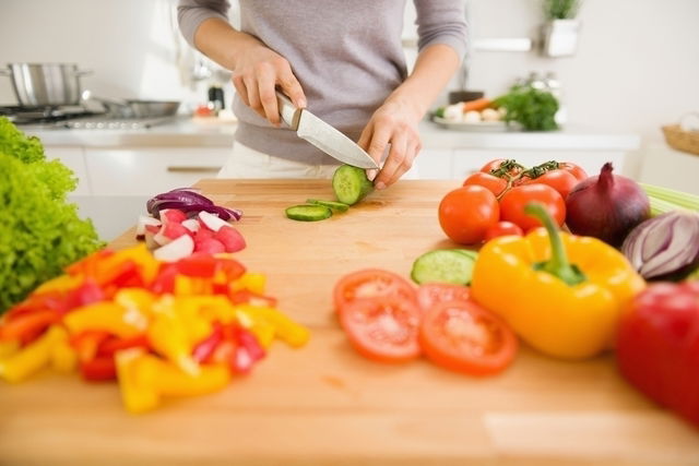 Man chopping vegetables in kitchen