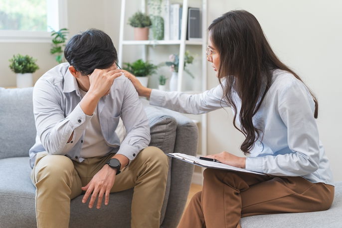 Psiquiatra acolhendo o paciente enquanto explica os seus sintomas durante a consulta.