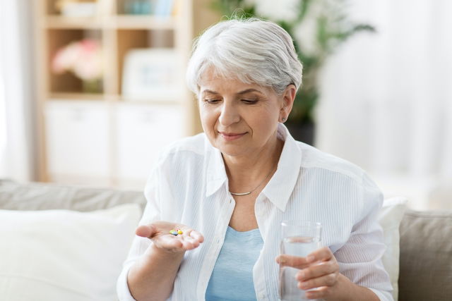 Señora con una pastilla en la mano