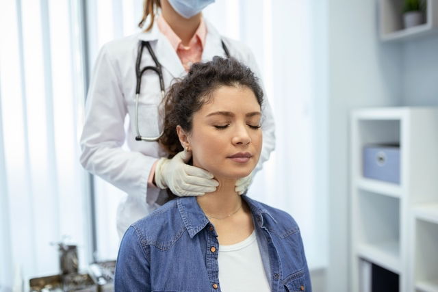 Médecin examinant le cou d’un patient.