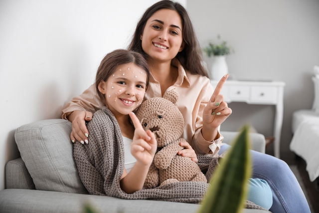 Mãe cuidando da filha com catapora