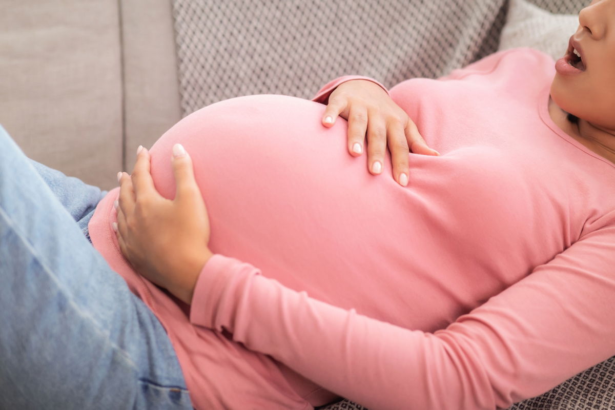Mulher grávida com a mão na barriga