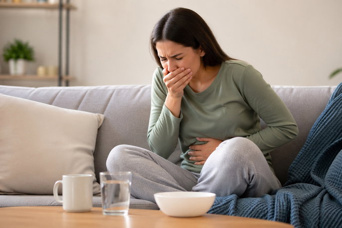 Woman experiencing intense nausea and abdominal pain | AI-generated image