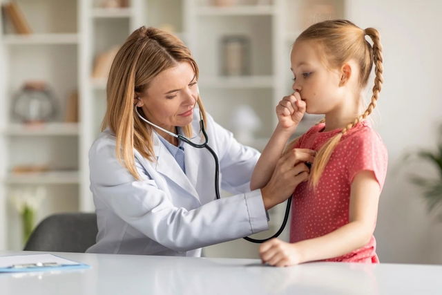 Médico auscultando el pecho de una paciente infantil