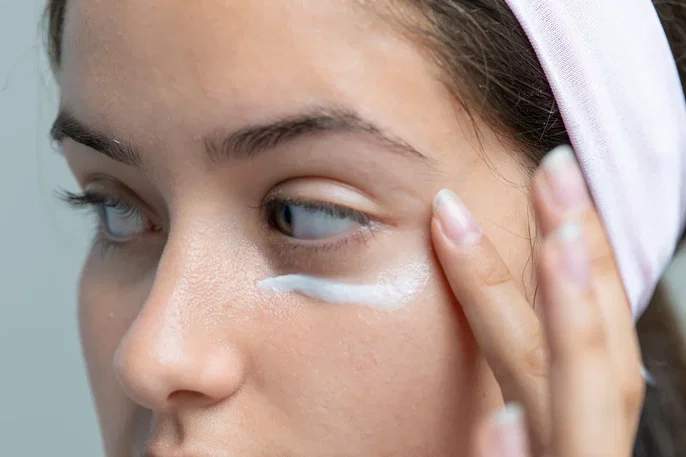 Mujer aplicandose crema para las ojeras