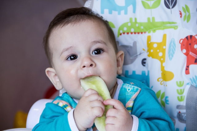 bébé assis qui mange seul