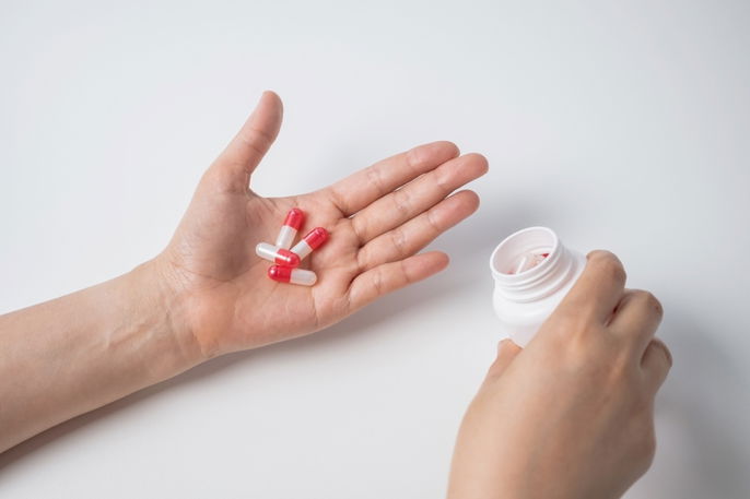 Patient reviewing capsules in palm