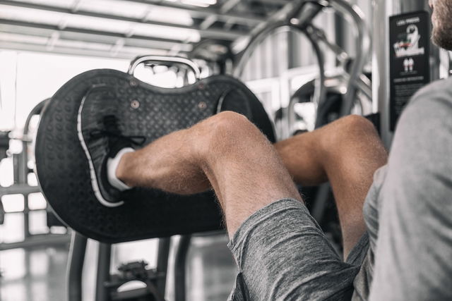 Homem fazendo um exercício para a coxa na academia