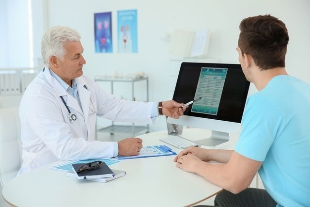 Médico mostrando resultados de exámenes a un paciente