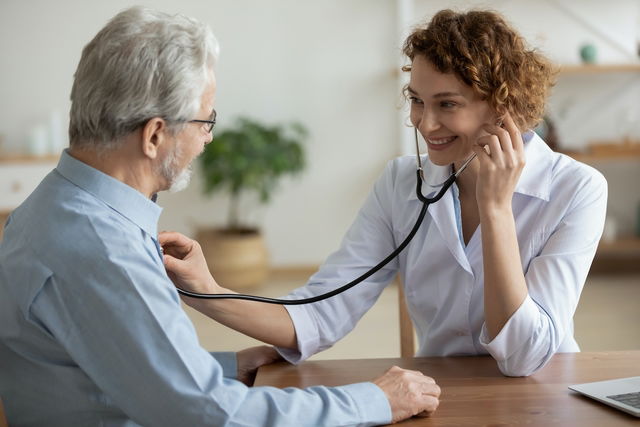 Médica ouvindo o coração de um paciente durante o exame 