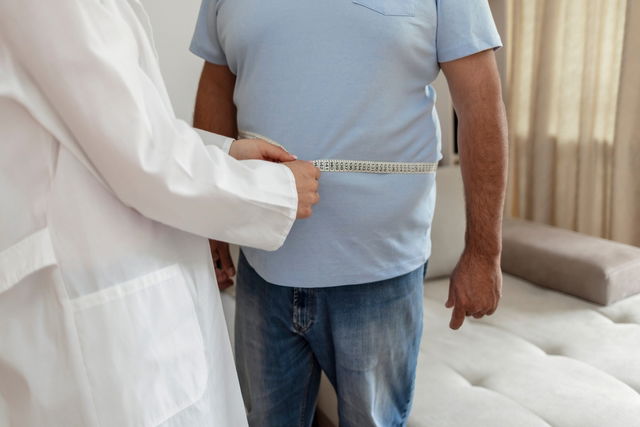 médecin qui mesure le tour de taille d'un homme