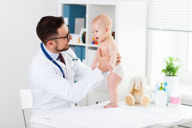 Médico examinando um bebê durante a consulta