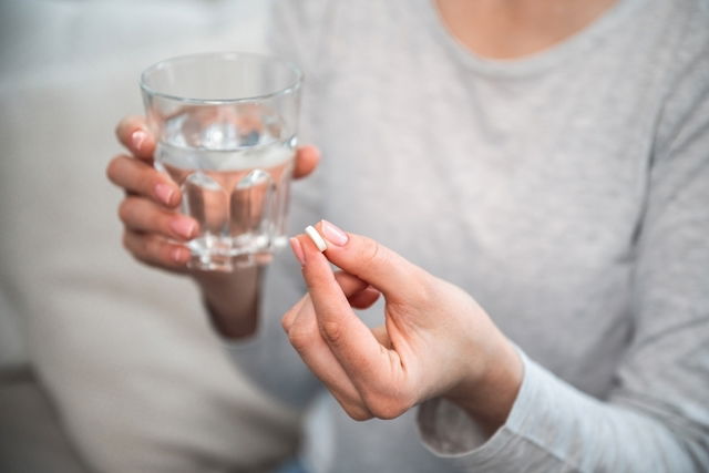 Mujer tomando una pastilla de dexketoprofeno