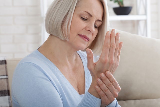 Mujer agarrándose la mano derecha