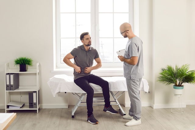 Homme chez le médecin souffrant d'inconfort intestinal