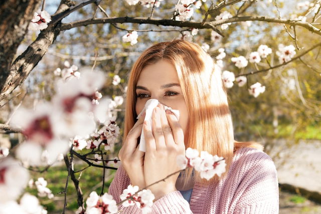 femme en train de se moucher à cause d'une allergie