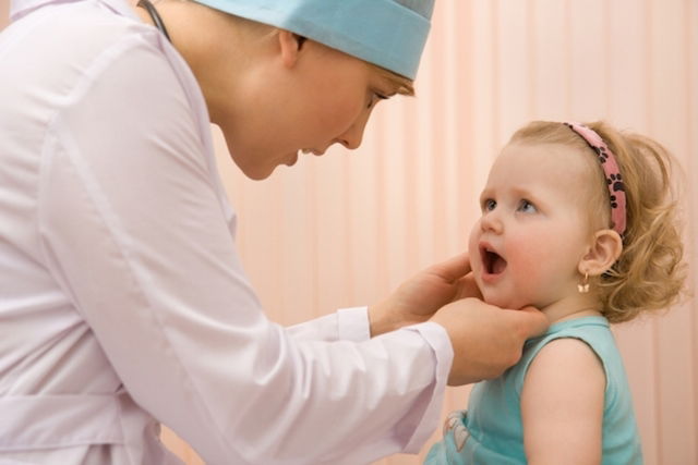 Pediatra examinando a cavidade oral de uma bebê