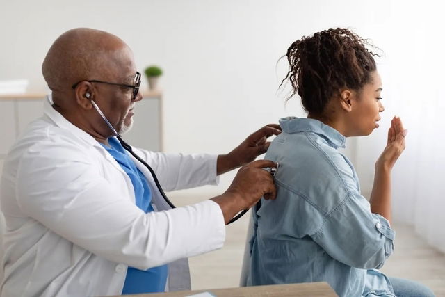 Médico auscultando a una paciente