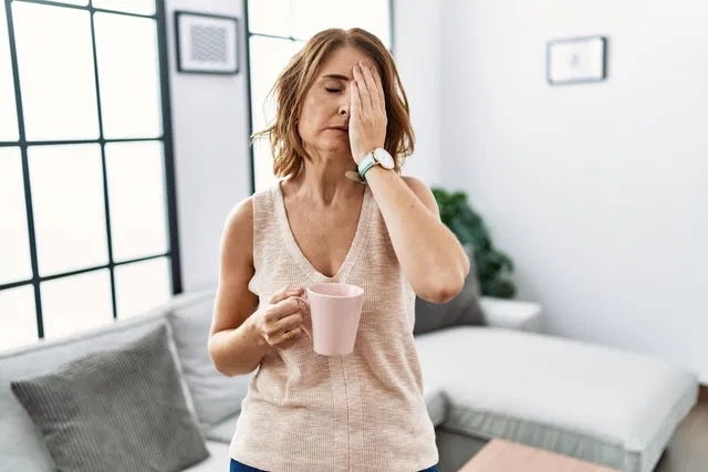 Mujer mayor con una taza de café cansada