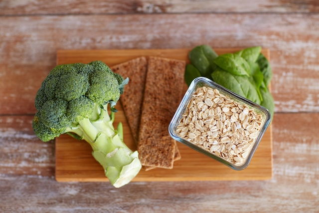 Tabla con un brócoli y un pote con avena