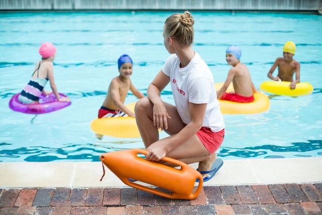 maître-nageur en train de surveiller des enfants à la piscine