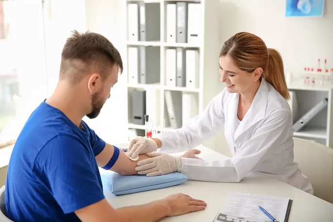 Médico tomando una muestra de sangre del brazo de un paciente