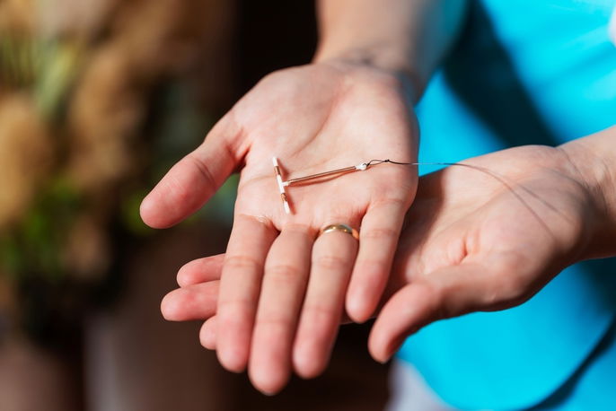 copper IUD in the palm of a hand