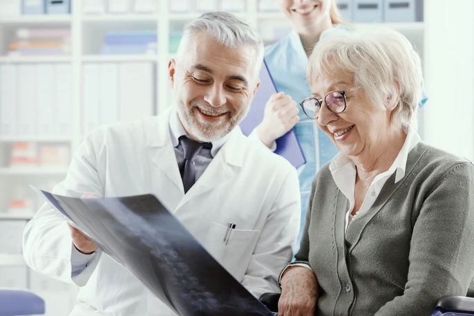 Médico viendo la radiografía de su paciente con espondilosis
