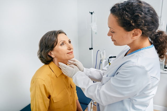 médecin palpant les ganglions lymphatique d'une patiente