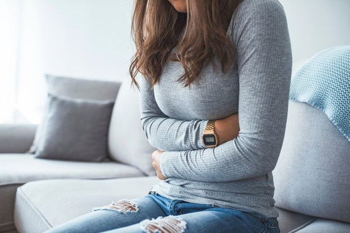 woman with arms wrapped around her abdomen