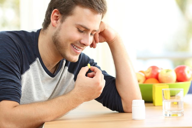 Hombre tomando una pastilla