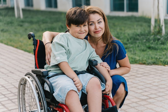 Mother with son in wheelchair, diagnosed with SMA